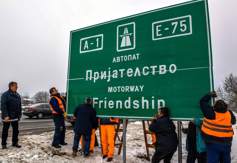 Bildet viser folk som henger opp et nytt skilt for motorveien i Makedonia.