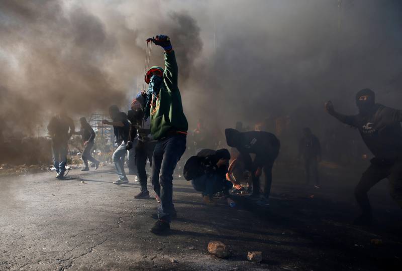 PROTEST: Palestinere kaster stein på israelske soldater i Ramallah på Vestbredden.