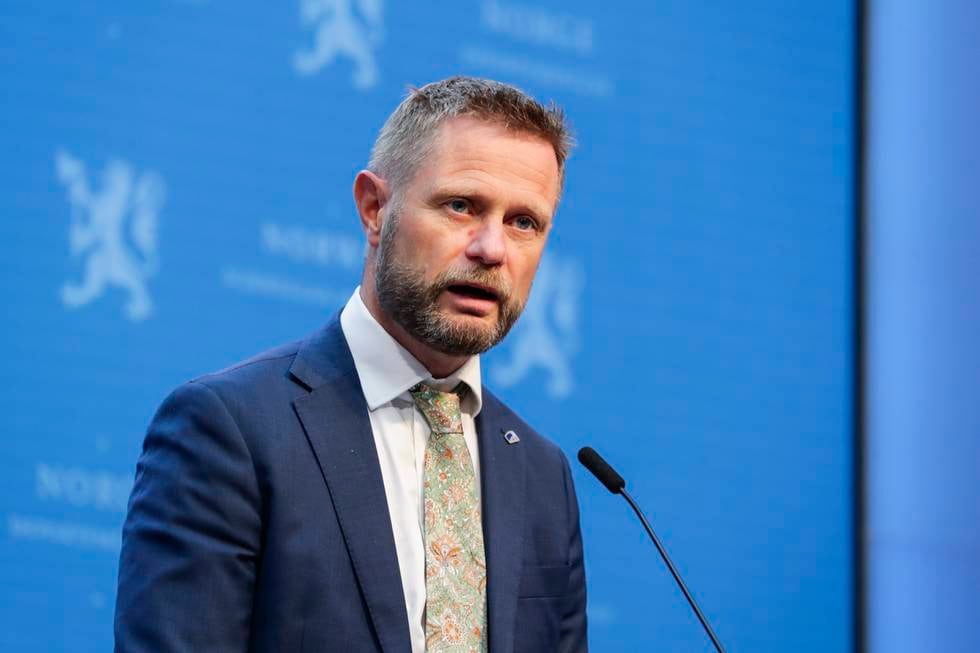 Bildet er av helseminister Bent Høie. Han står foran en blå vegg og bak en mikrofon.