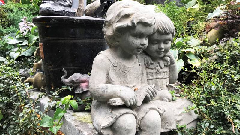Bildet viser en statue av en to små barn i hagen.