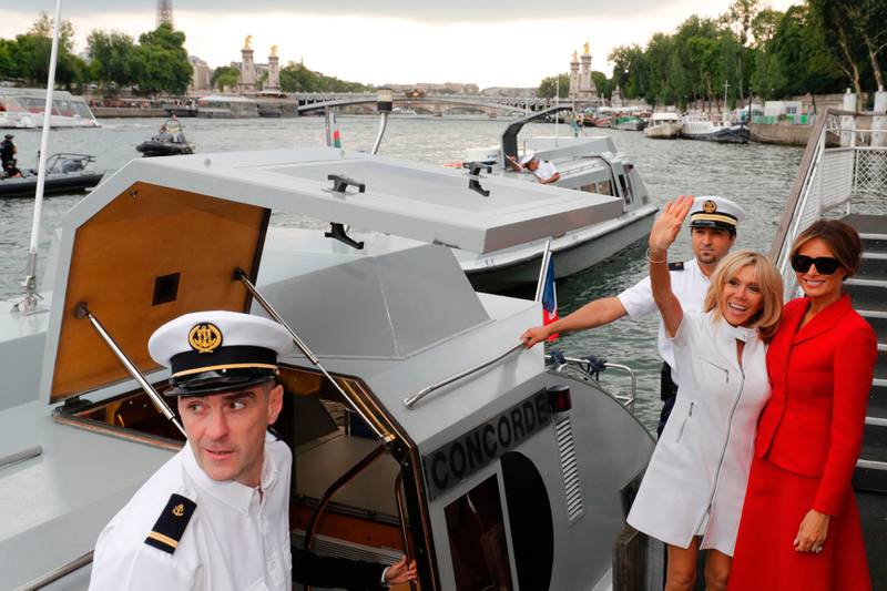 Bildet viser Melania Trump og Brigitte Macron som går om bord i en båt.
