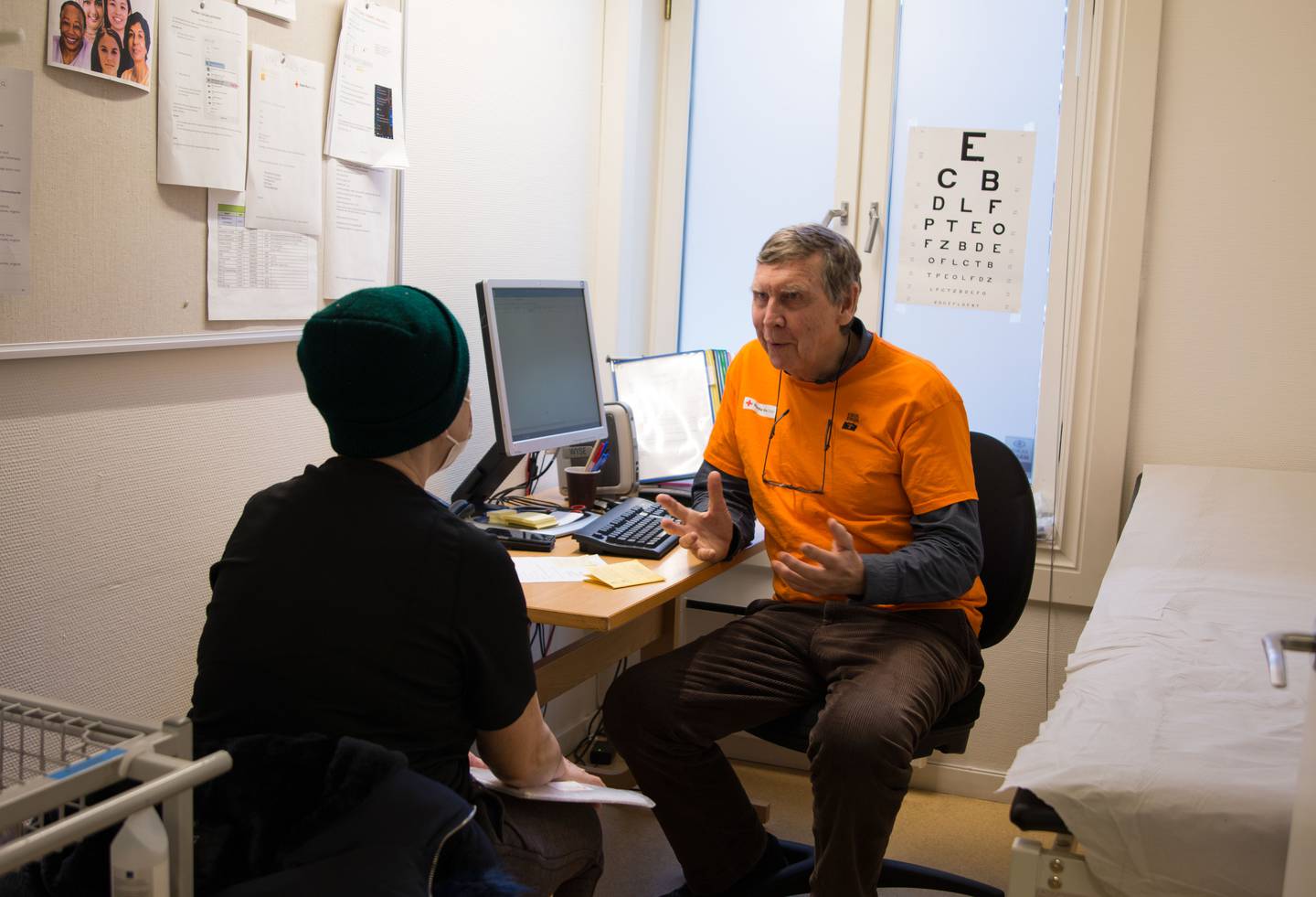 Bildet viser Per Stensland som snakker med en pasient på kontoret sitt.