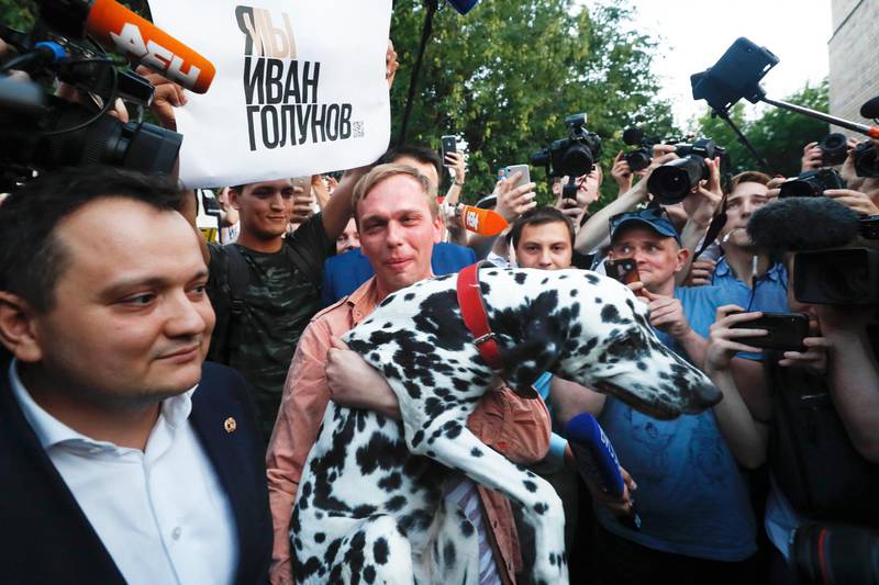 Bildet viser Ivan Golunov som bærer hunden sin. 
