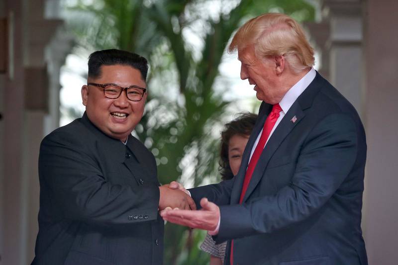 Bildet viser Kim Jong-un som smiler og tar Donald Trump i hånden. Slik har vi ikke vært vant til å se Kim. For første gang møtte en nordkoreansk leder en amerikansk president.