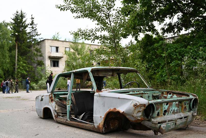 Bildet viser det rustne vraket av en bil uten hjul i byen Pripjat i Ukraina.