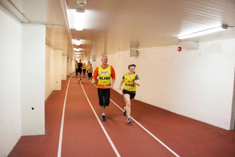 Bildet viser Håkon Gisholt som løper ved siden av en ledsager. Trening er veldig viktig for ham. Hver onsdag samles Team RP til løpetrening på Bislett i Oslo. Der løper deltakerne og ledsagere sammen. 