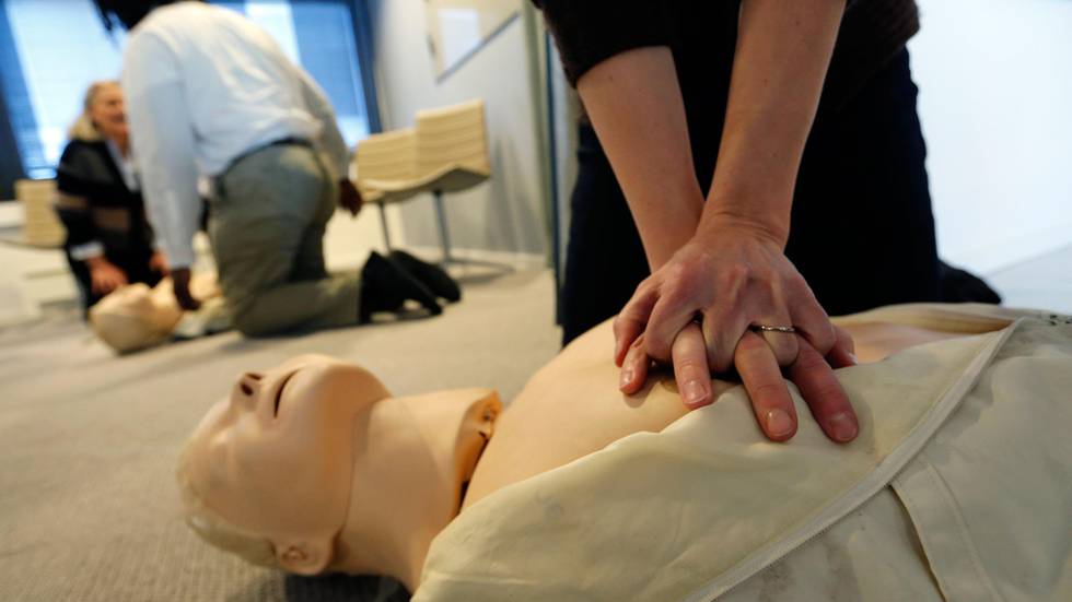 Bildet viser en person som gir hjerte- og lungeredning. Det er en øvelse, og den syke er en dukke.