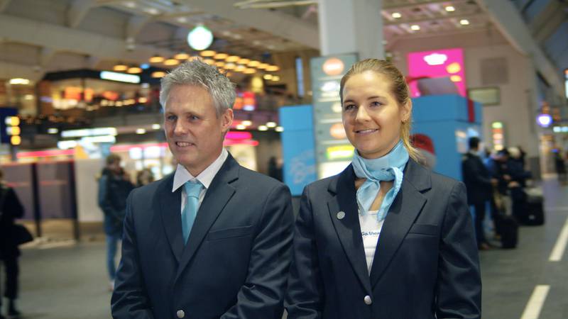 Bildet viser to ansatte i Go-Ahead i nye uniformer. Overdelene er hvite. Jakkene er mørkeblå. Mannen har et lyseblått slips. Kvinnen har et lyseblått tørkle om halsen.