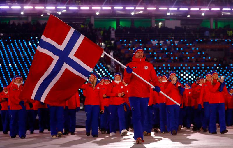 Bildet viser det norske laget under åpningsseremonien i OL. Emil Hegle Svendsen holder det norske flagget.