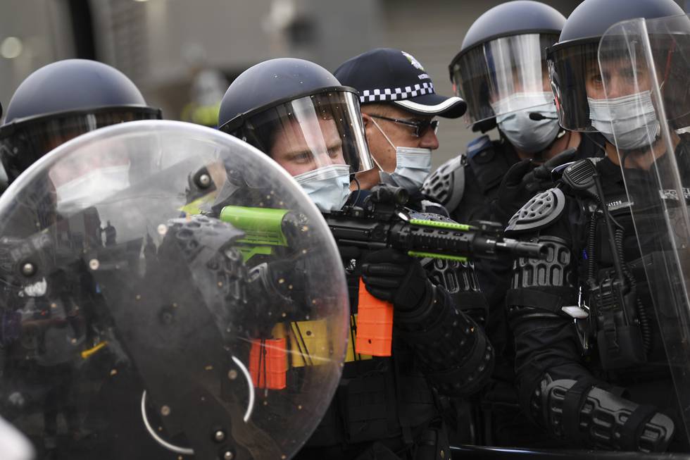 Politiet tok i bruk hjelmer, skjold og pepperspray da tusenvis av australiere demonstrerte mot nedstengningene i landet. Foto: James Ross / AAP Image via AP / NTB