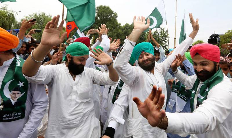 Bildet viser menn med turbaner som danser. De tilhører religionen sikh og bor i Peshawar i Pakistan.