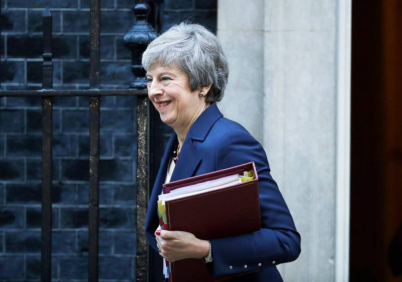British Prime Minister Theresa May smiles as she leaves 10 Downing Street heading to Parliament for Prime Minister's questions in London, Wednesday, Nov. 14, 2018. May will try to persuade her divided Cabinet on Wednesday that they have a choice between backing a draft Brexit deal with the European Union or plunging the U.K. into political and economic uncertainty. (AP Photo/Matt Dunham)
