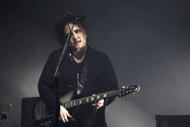 Bildet viser Robert Smith fra The Cure med gitar på scenen.