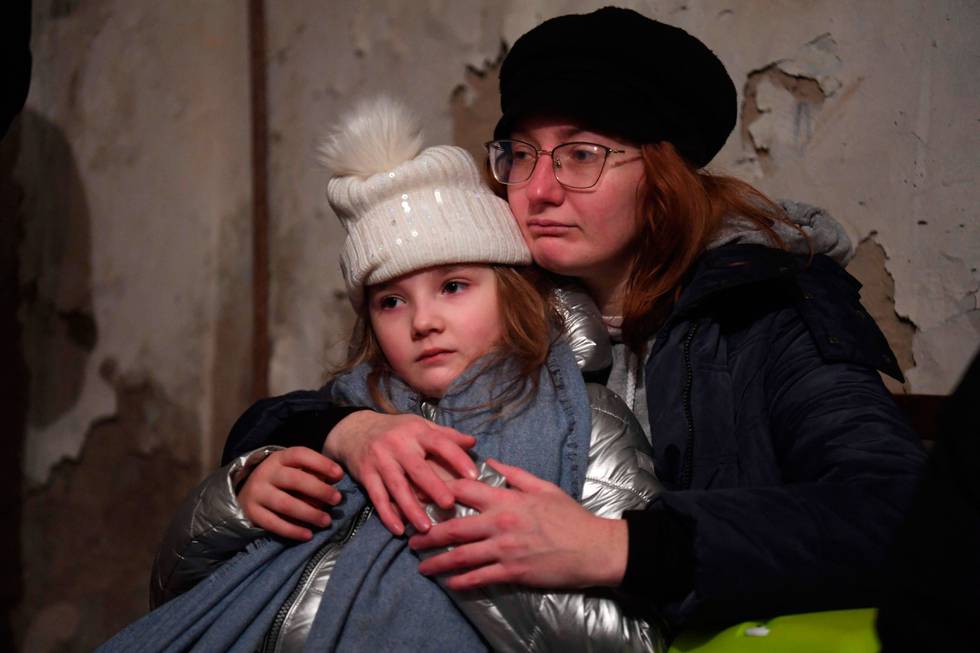 Bildet viser Helga Tarasova som klemmer datteren Kira Shapovalova. De sitter i et bomberom i Kyiv lørdag 26. februar.