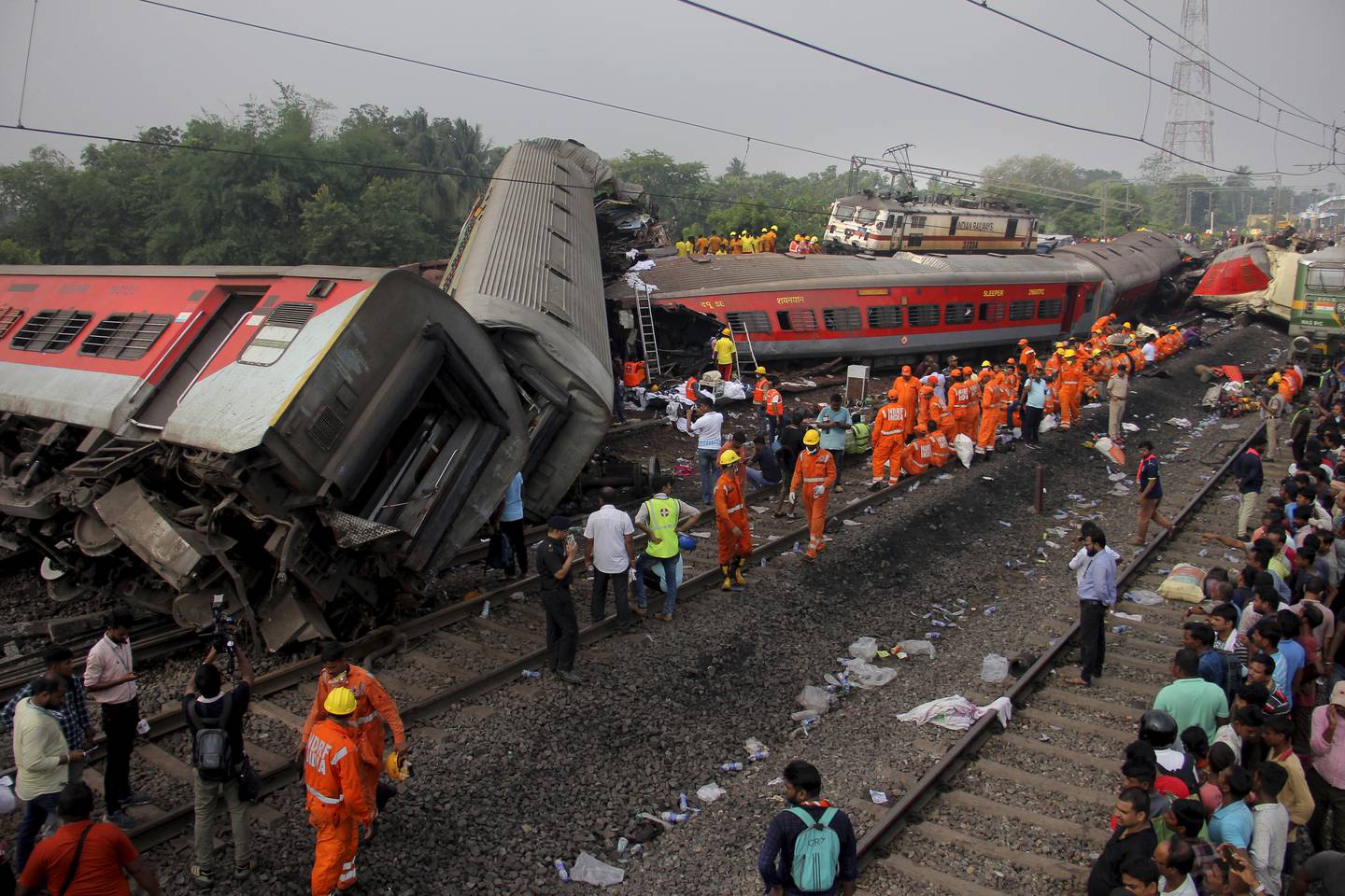 Redningsarbeidere på stedet der to tog var involvert i en massiv avsporing og kollisjon i den østlige delstaten Odisha i India lørdag. Foto: AP/NTB
