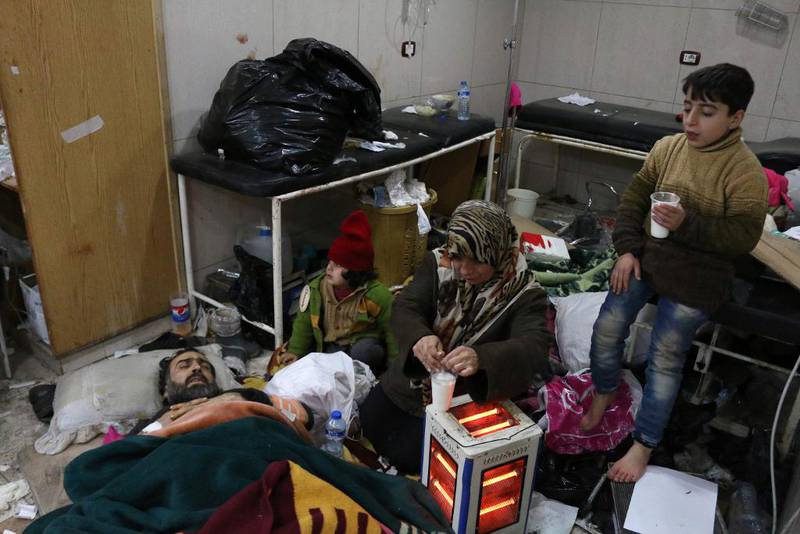 Bildet viser en familie som venter på å få reise fra Øst-Aleppo. Faren ligger på gulvet og er syk.