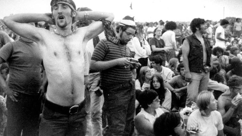 Bildet viser folk som slapper av mellom konserter på Woodstock.