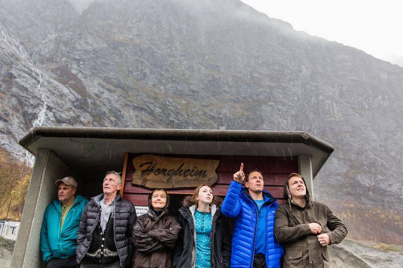 Bildet viser folk som ventet på skred fra fjellet Mannen i 2014. De står i et busskur.