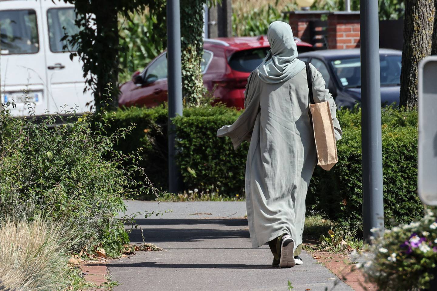 En dame har på seg et langt kjolelignende klesplagg, som kalles abaya.