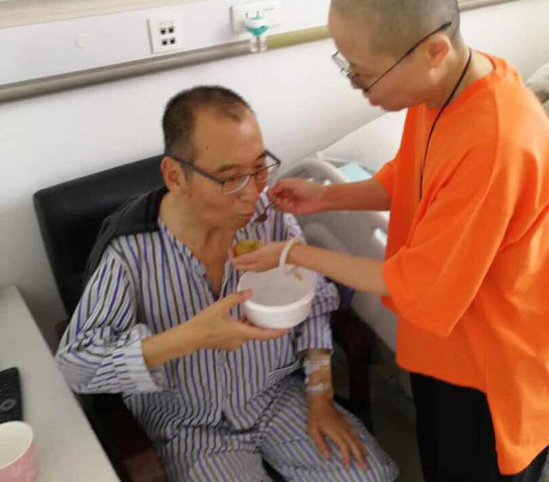 Bildet viser  Liu Xiaobo som får hjelp av noen på et sykehus.