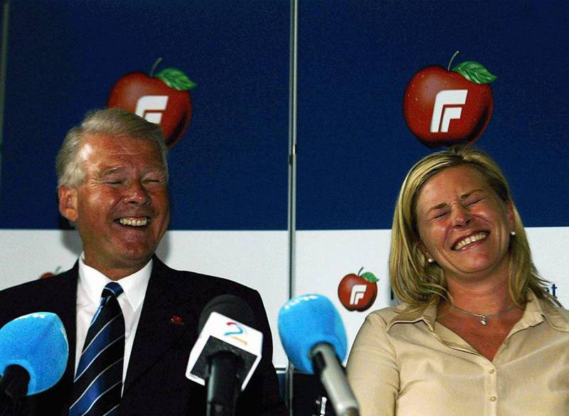 Bildet viser Siv Jensen og Carl I. Hagen. De ler på en pressekonferanse.