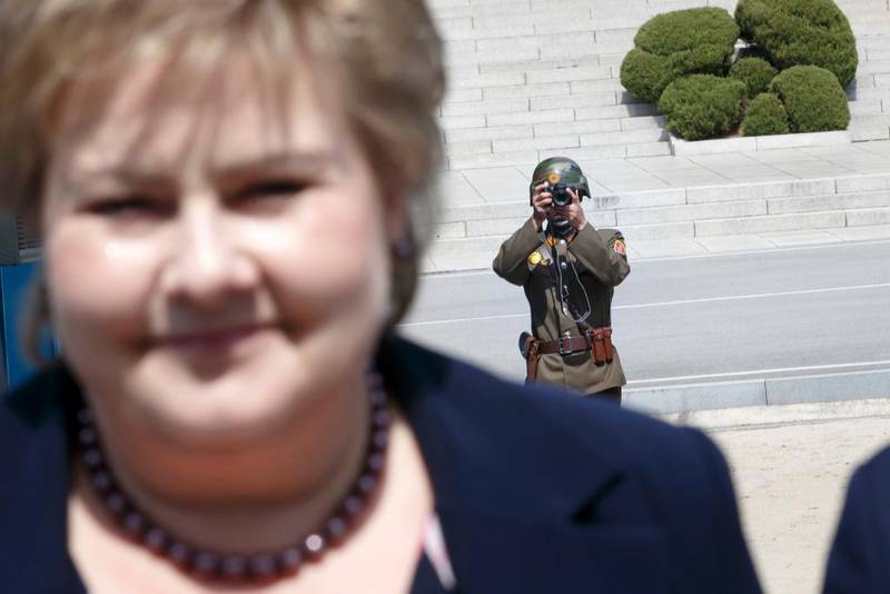 Bildet viser en soldat fra Nord-Korea som tar bilde av Erna Solberg.