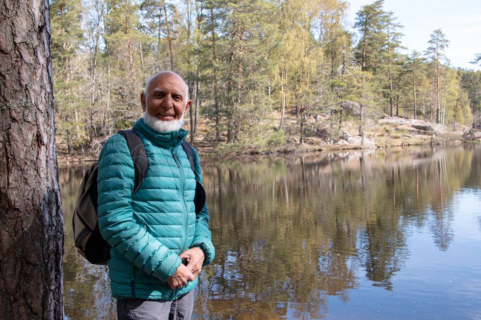 Bildet er av Abdur Razzaq. Han er en eldre mann med hvitt skjegg og turklær. Han står ved et vann og i bakgrunnen er det trær. Foto: Petter Johansen Skipperø / Klar Tale