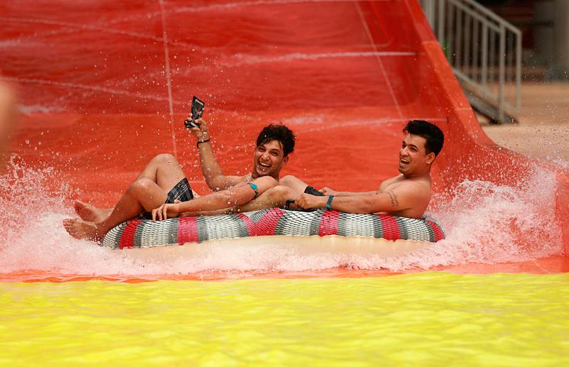Bildet viser to menn som kjører i en stor badering i en vannpark i Irak.