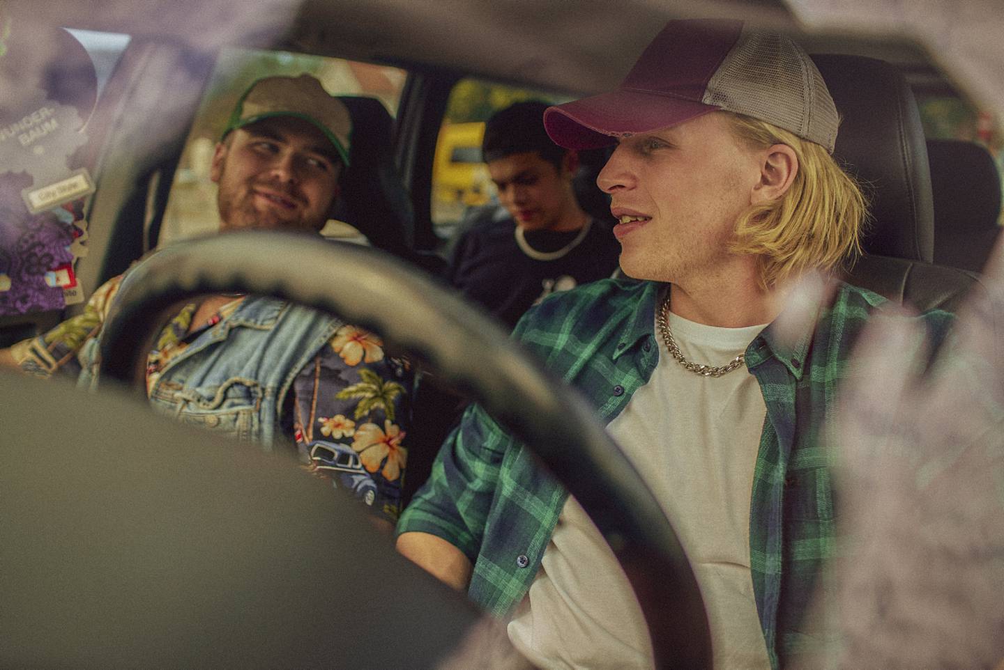 Bildet er av karakterene Nilsen, GT og Kim fra serien Rådebank. De sitter inne i en bil.