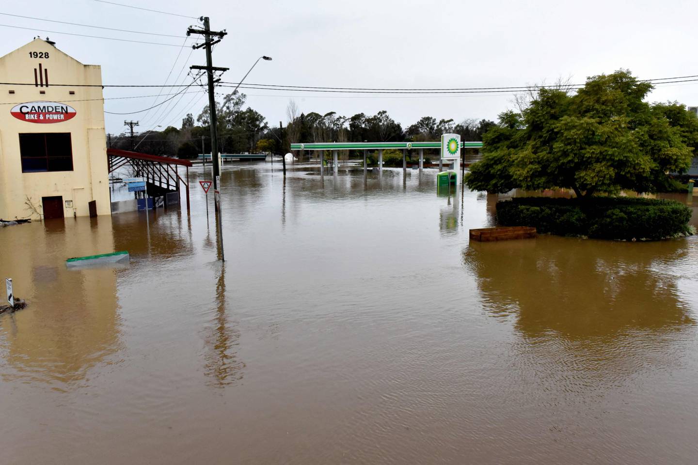 Bildet er fra byen Camden vest for Sydney. Vannet står i gatene så langt det er mulig å se. En bensinstasjon står under vann. Foto: Muhammad Farooq / AFP / NTB