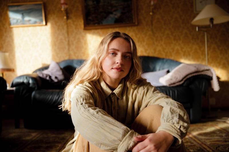 Bildet er av Hilde Skaar som sitter i en gul stue.