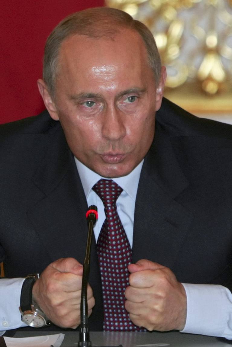 Bildet er av Vladimir Putin i 1999. Han har på dress og sitter ved en pult. Han har begge nevene knyttet foran seg. Foto: Sergei Chirikov / AP / NTB