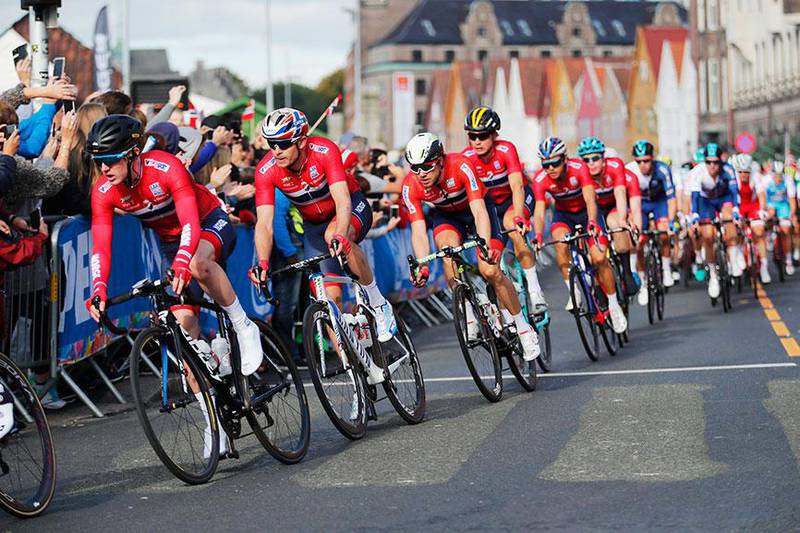 Bildet viser deltakere i VM i landeveissykling i Bergen i 2017. Syklistene suser forbi Bryggen i Bergen. Norske syklister får en ny sjanse til å vise seg fram i VM i september.