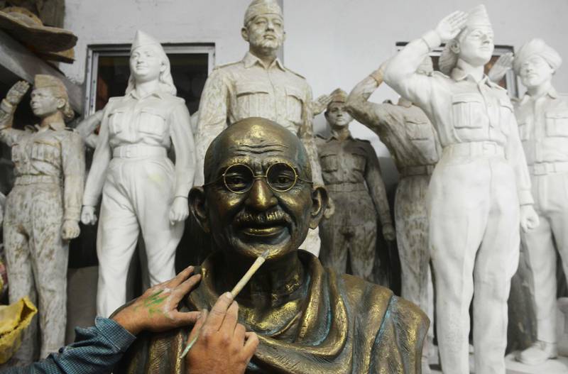 Bildet viser en statue av Mahatma Gandhi som en kunstner jobber med.