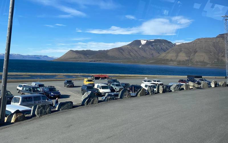Bildet viser parkeringsplassen utenfor Svalbard lufthavn. Campingen ligger bak parkeringen. Det er tatt tidligere i sommer.