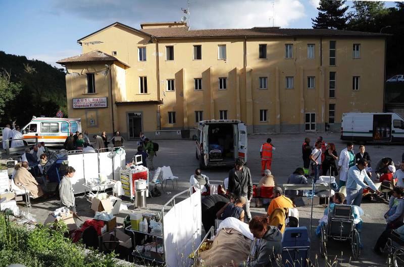MOTTAK: Helsearbeidere tar imot skadde utenfor sykehuset i Amatrice. 
