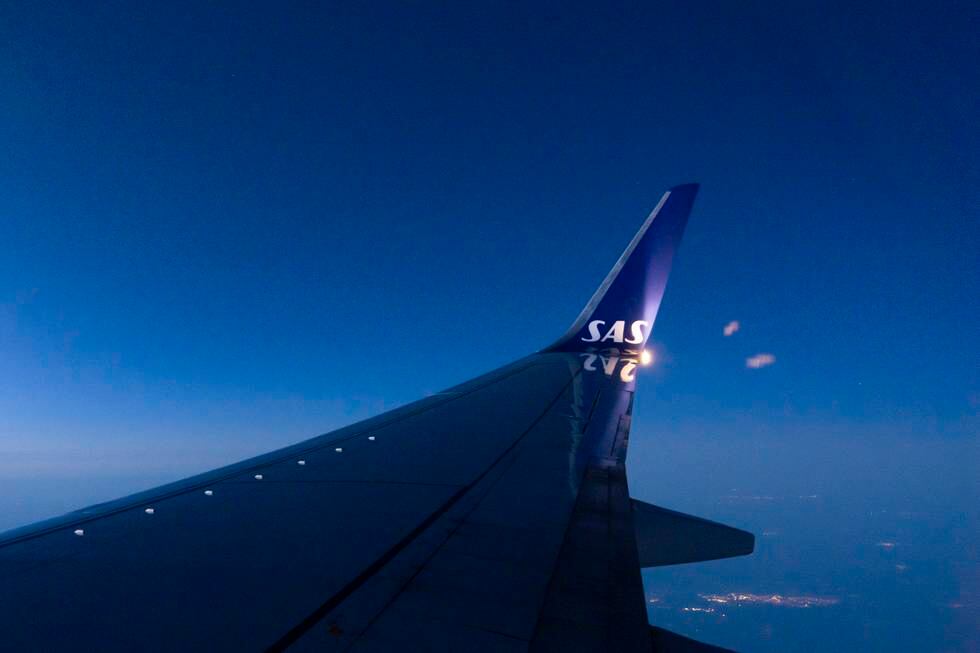 Bildet er av vingen på et SAS-fly. Bildet er tatt fra innsiden av flyet mens det er i luften. Det er SAS-logo på vingen. Foto: Erik Johansen / NTB