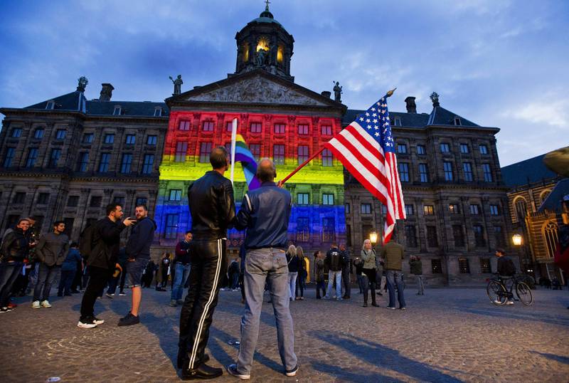 Bildet viser det kongelige slott i Amsterdam i Nederland. Det er lyst opp i regnbuens farger.