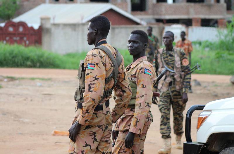 Bildet viser soldater og politi som står vakt i gatene i hovedstaden Juba. Nye kamper har startet i Sør-Sudan.