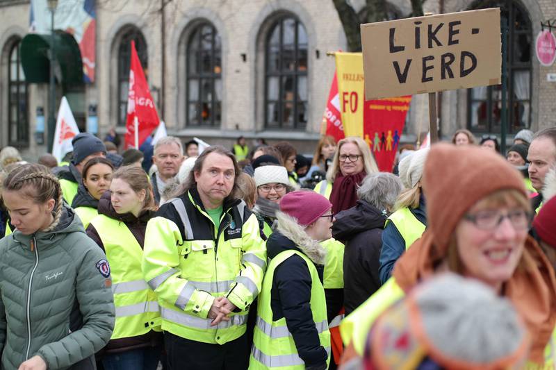 Bildet viser folk med protestplakater. De er samlet foran rådhuset i Trondheim.