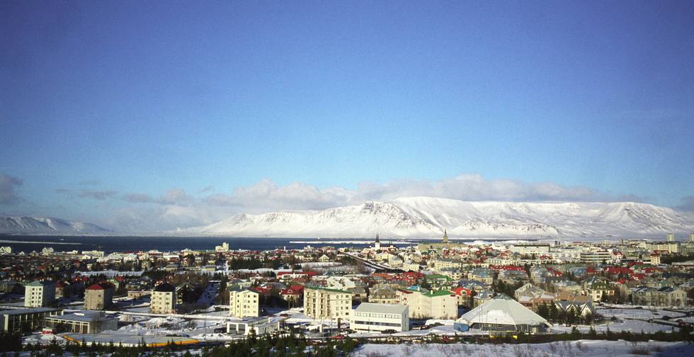 Bildet viser Reykjavik på Island med en isbre i bakgrunnen.