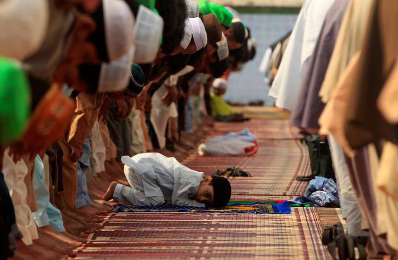 Bildet viser en liten gutt som er med på bønn i Pakistan.