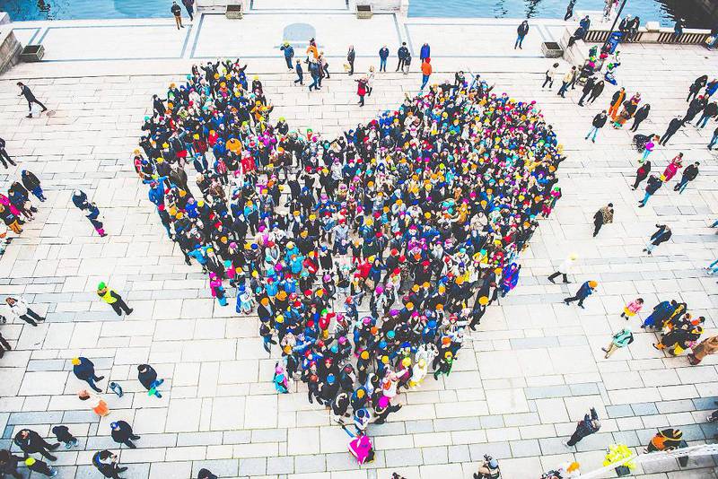 Bildet viser en samling av personer med turban fra luften. De står sammen og lager et hjerte.
