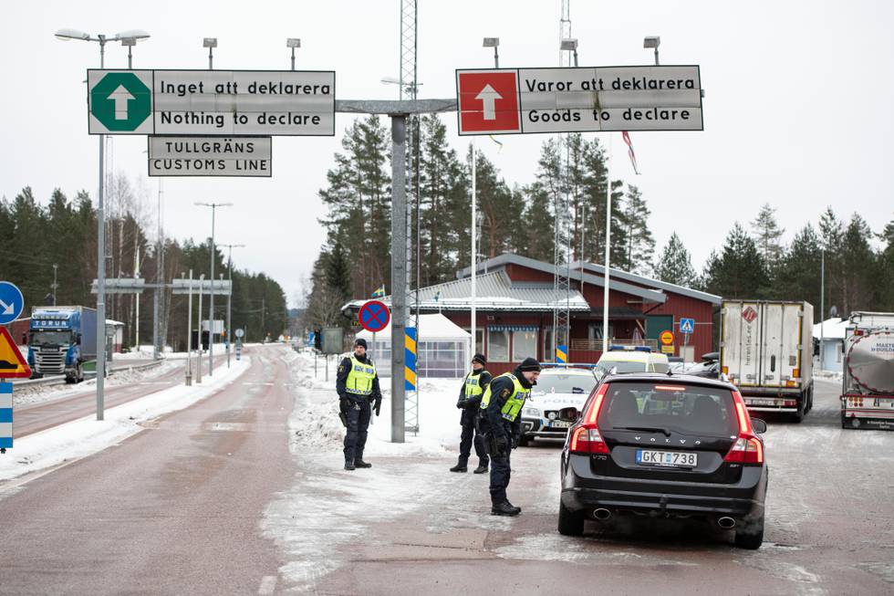 Tre personer i det svenske tollvesenet sjekker en bil for dokumentasjon for å reise inn til Sverige.