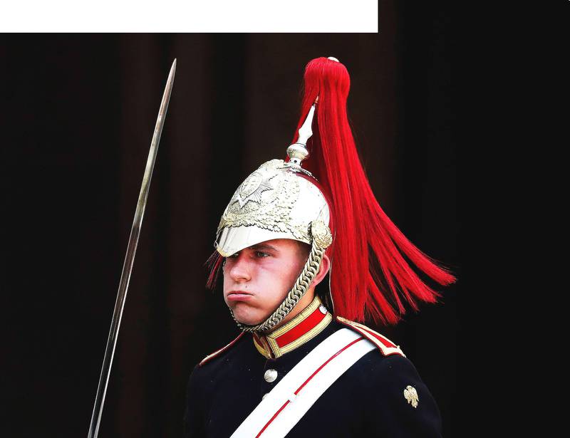 Bildet viser en vakt kledd i uniform og hjelm. Han puster tungt ut med munnen.