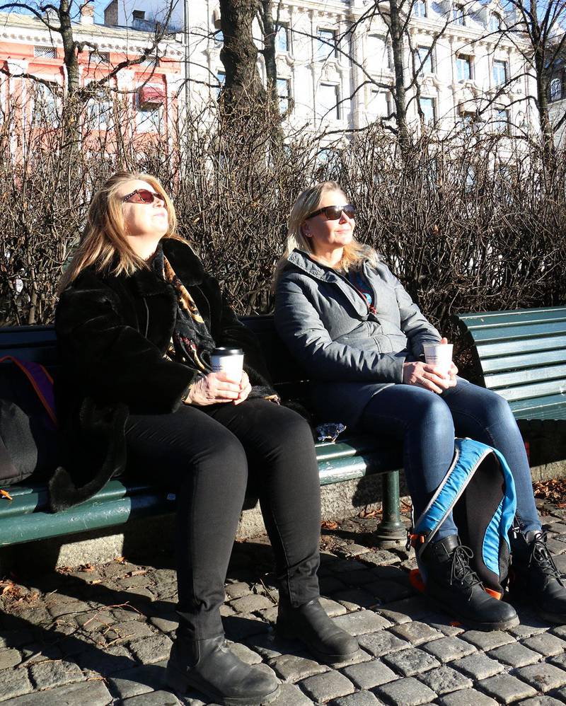Bildet viser venninnene Anne Meyer og Hege Gloppe. De sitter på en benk og koser seg i sola ved Spikersuppa i Oslo sentrum. 