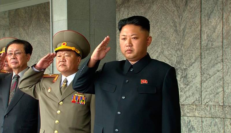 Bildet viser Kim Jong-un som gjør militær hilsen sammen med en mann i uniform.