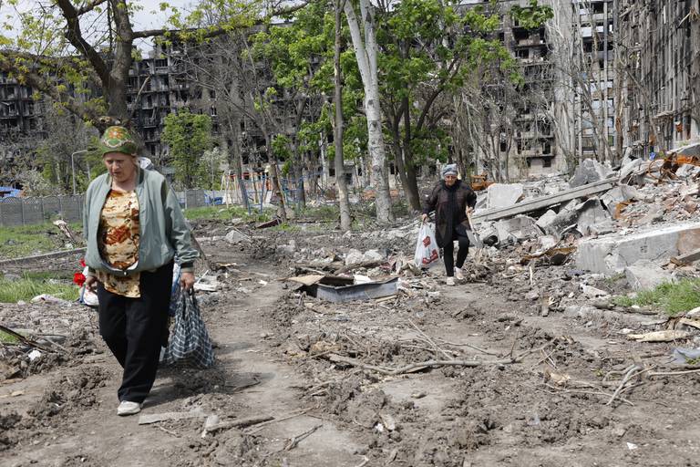 En kvinne ved en ødelagt bygning i Mariupol. Hvis Russland massemobiliserer, kan det bety at brutaliteten i Ukraina økes, mener forsker. Foto: Aleksej Aleksandrov / AP / NTB