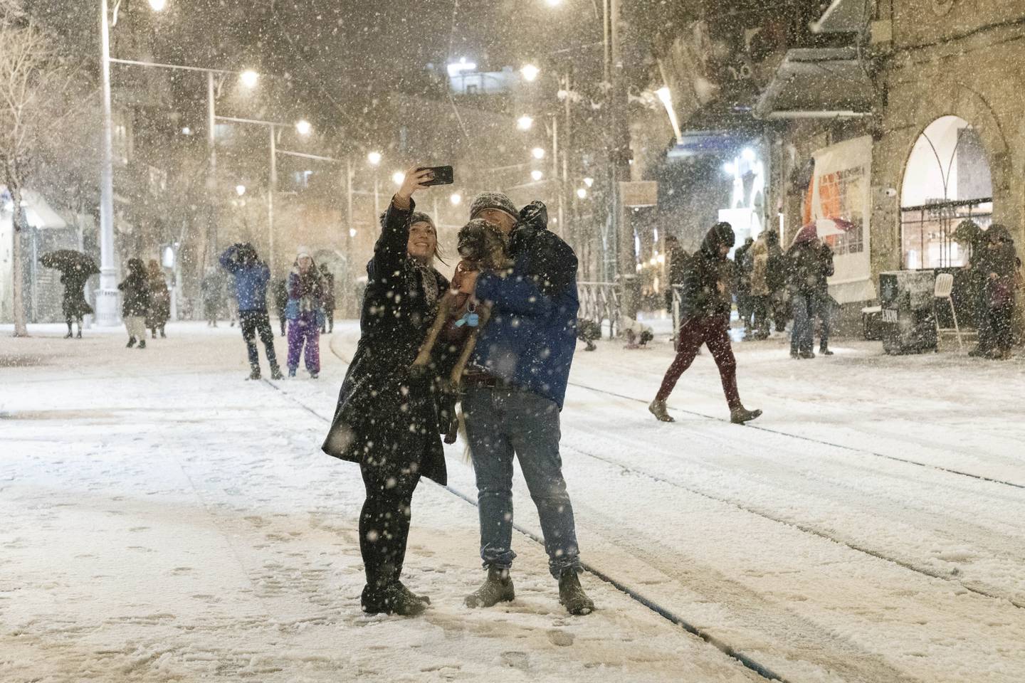 Folk tar selfier i snøværet på Machane Yahuda-markedet i Jerusalem. Foto: Maya Alleruzzo / AP / NTB