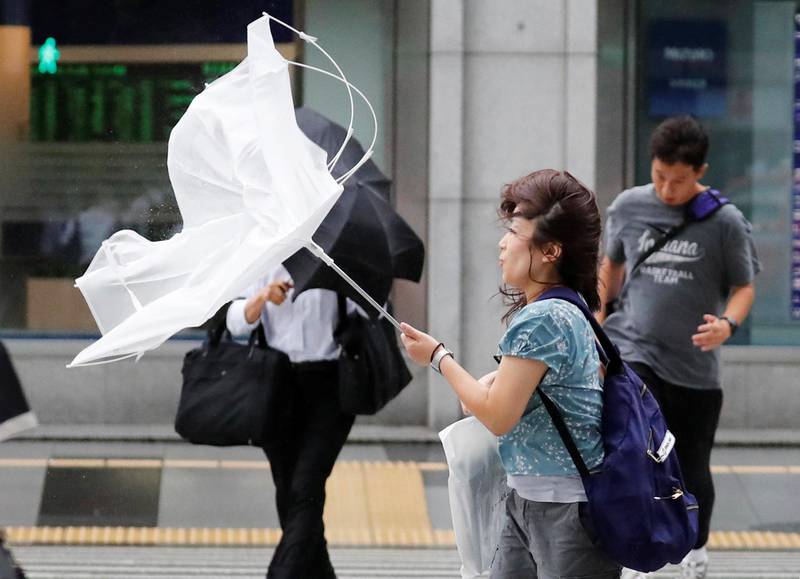 Bildet viser en kvinne som holder en knekt paraply i Tokyo.